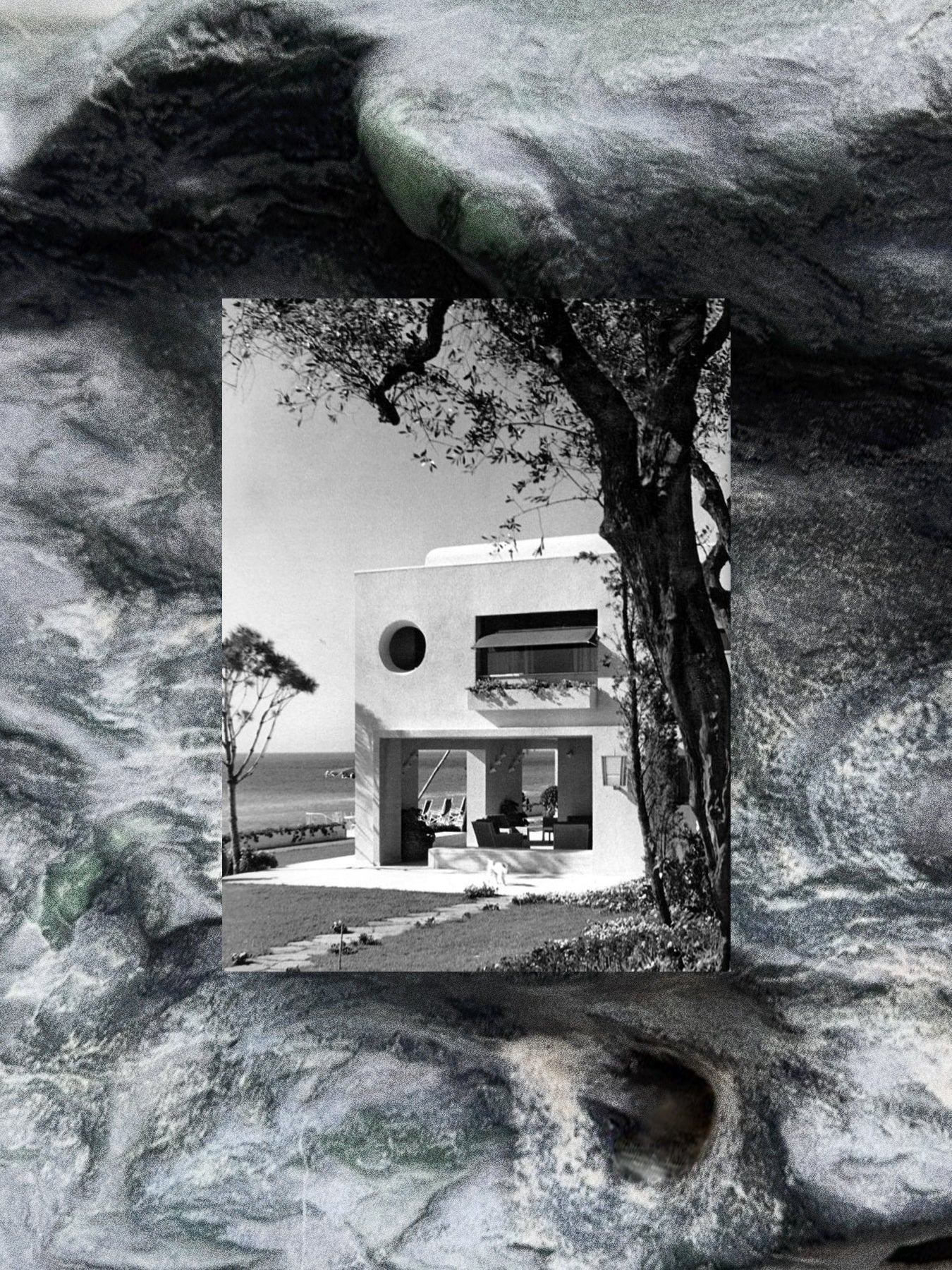 Modern house with a tree in the foreground, framed by a rocky texture