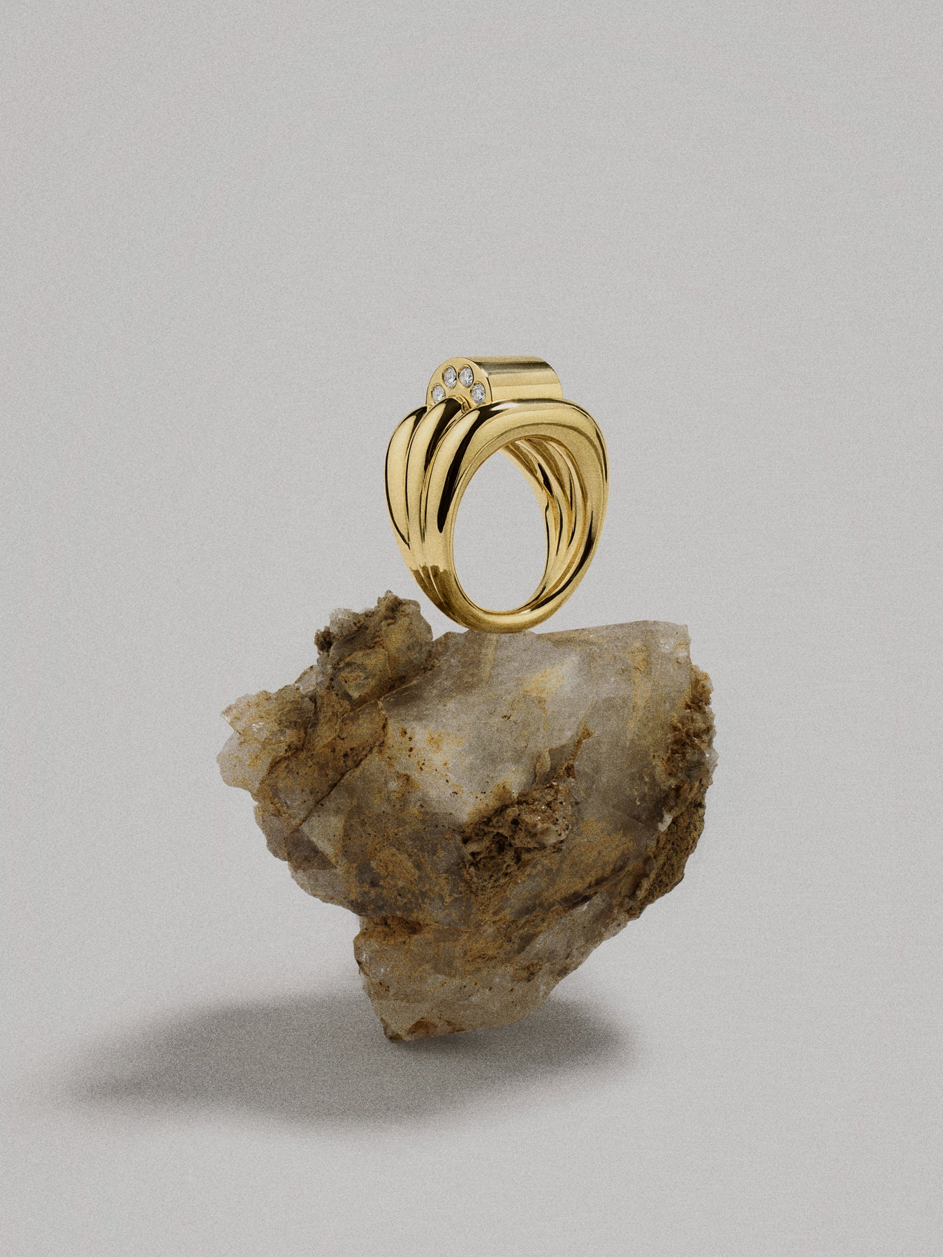 Gold ring on a textured stone against a gray background