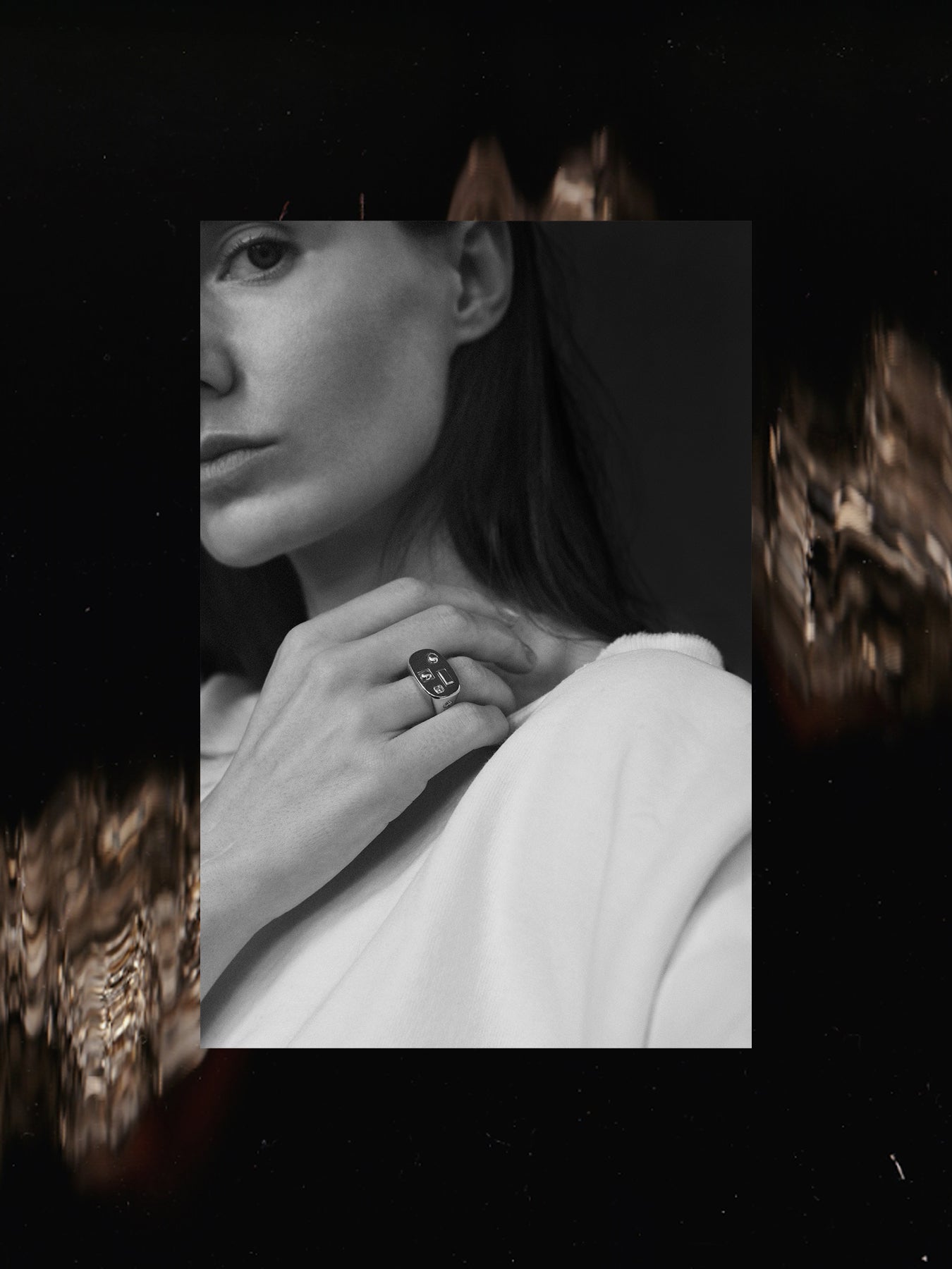 Close-up of a person wearing a ring with a dark abstract background