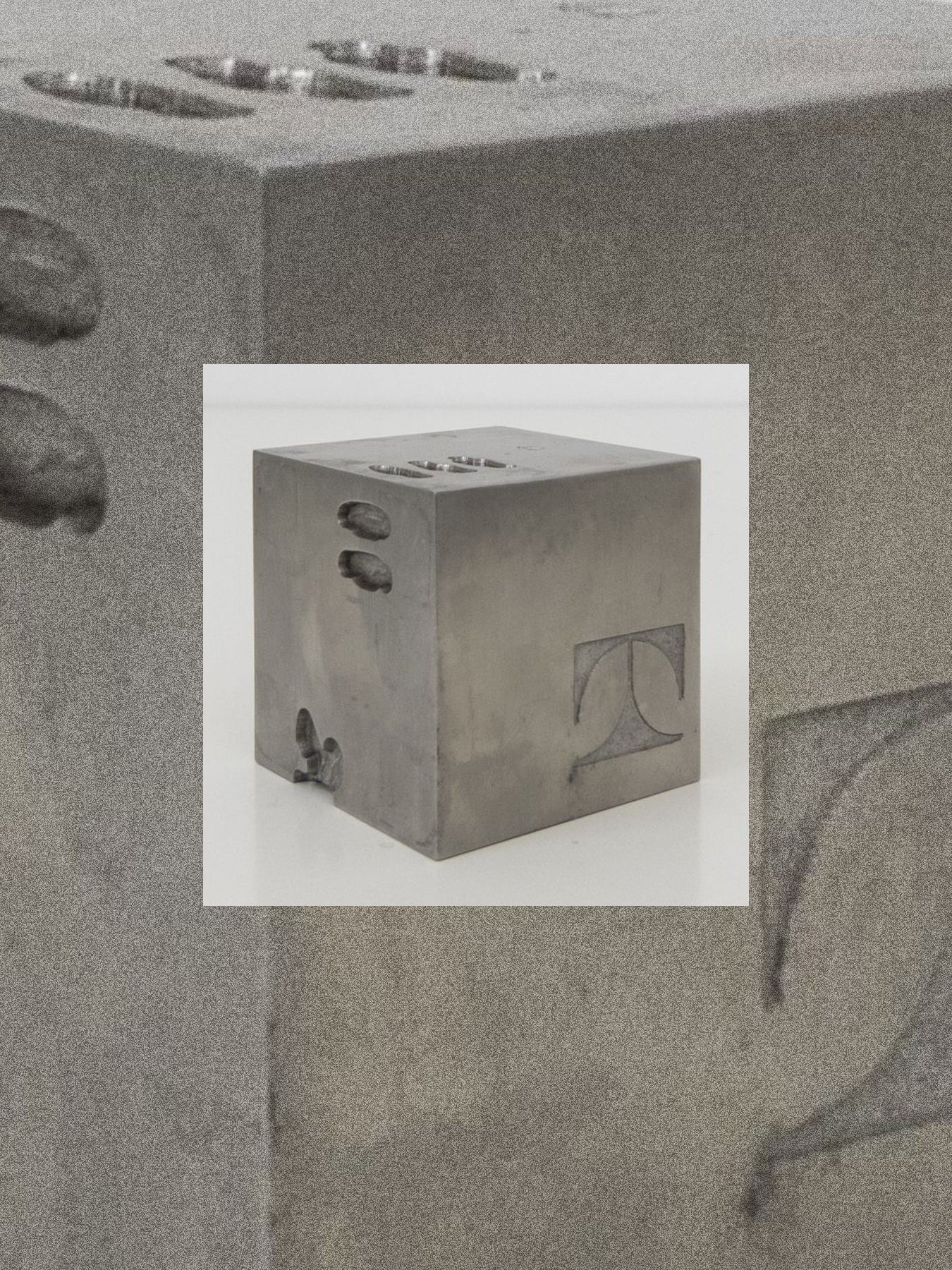 Concrete block with a smaller inset image of a concrete cube on a gray background