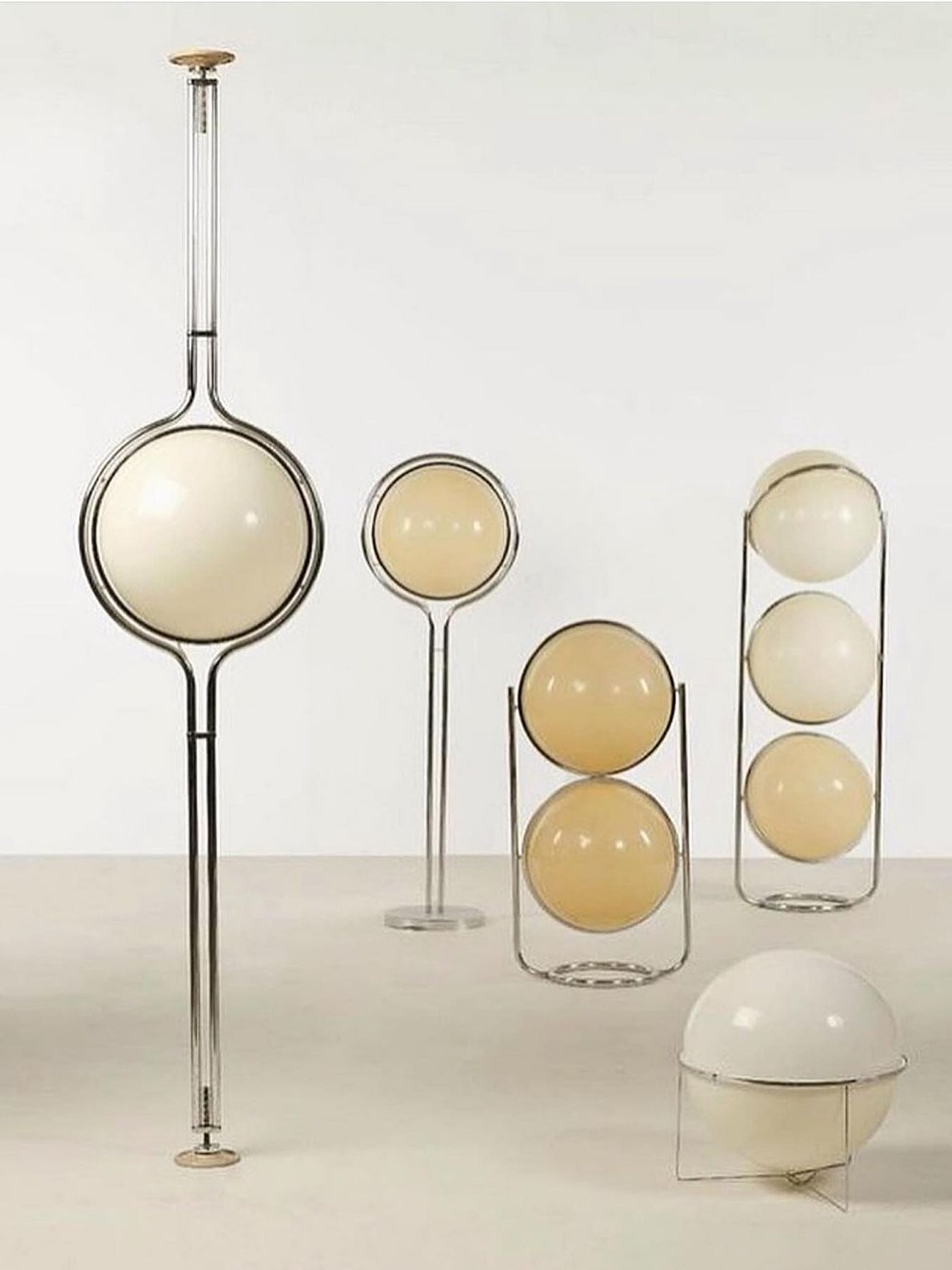 Set of modern pendant lights with spherical designs on a neutral background