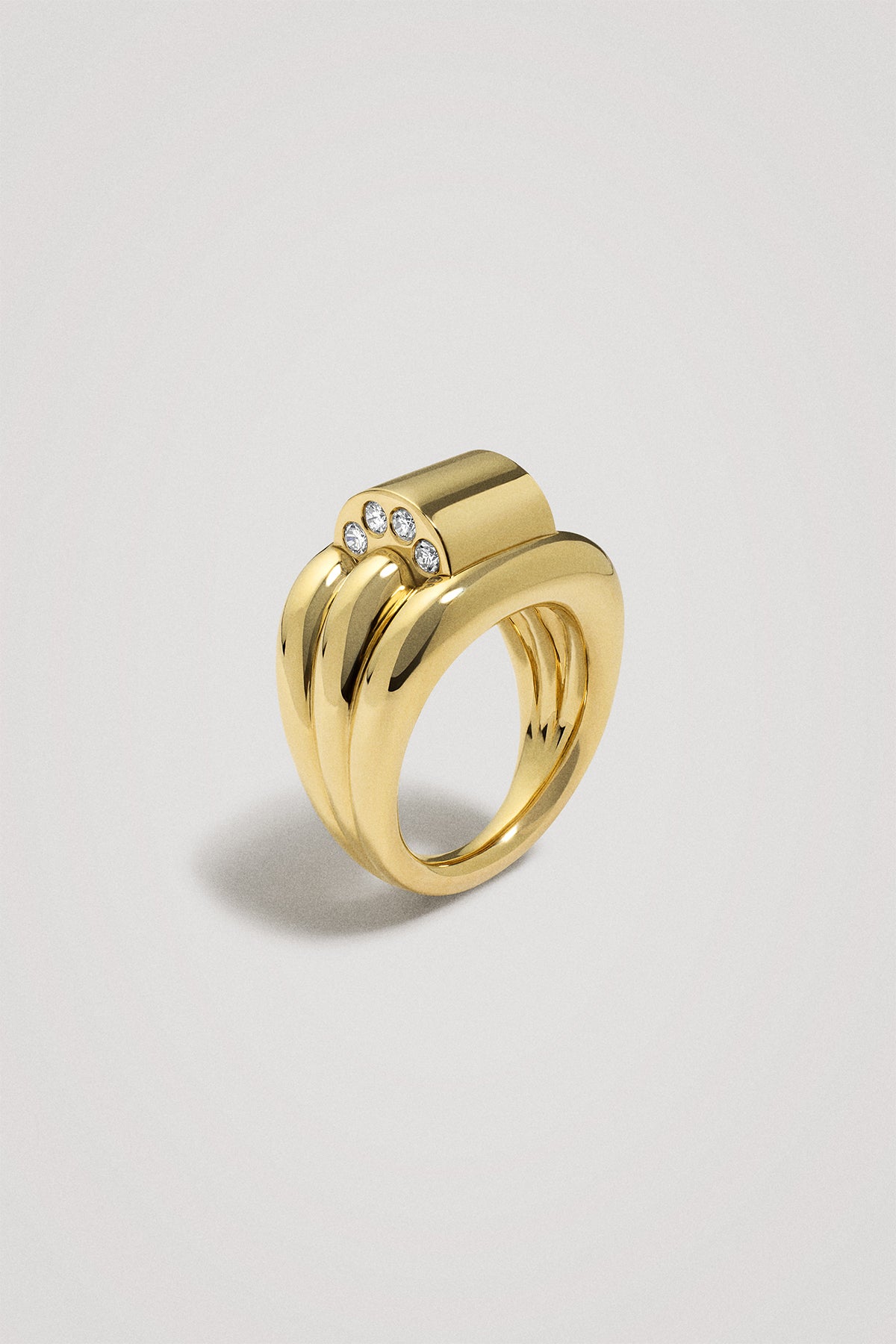 Gold ring with embedded stones on a light gray background