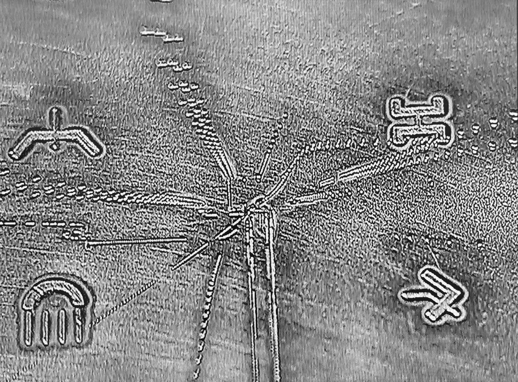 Close-up of a metallic surface with geometric patterns and symbols of INUH code