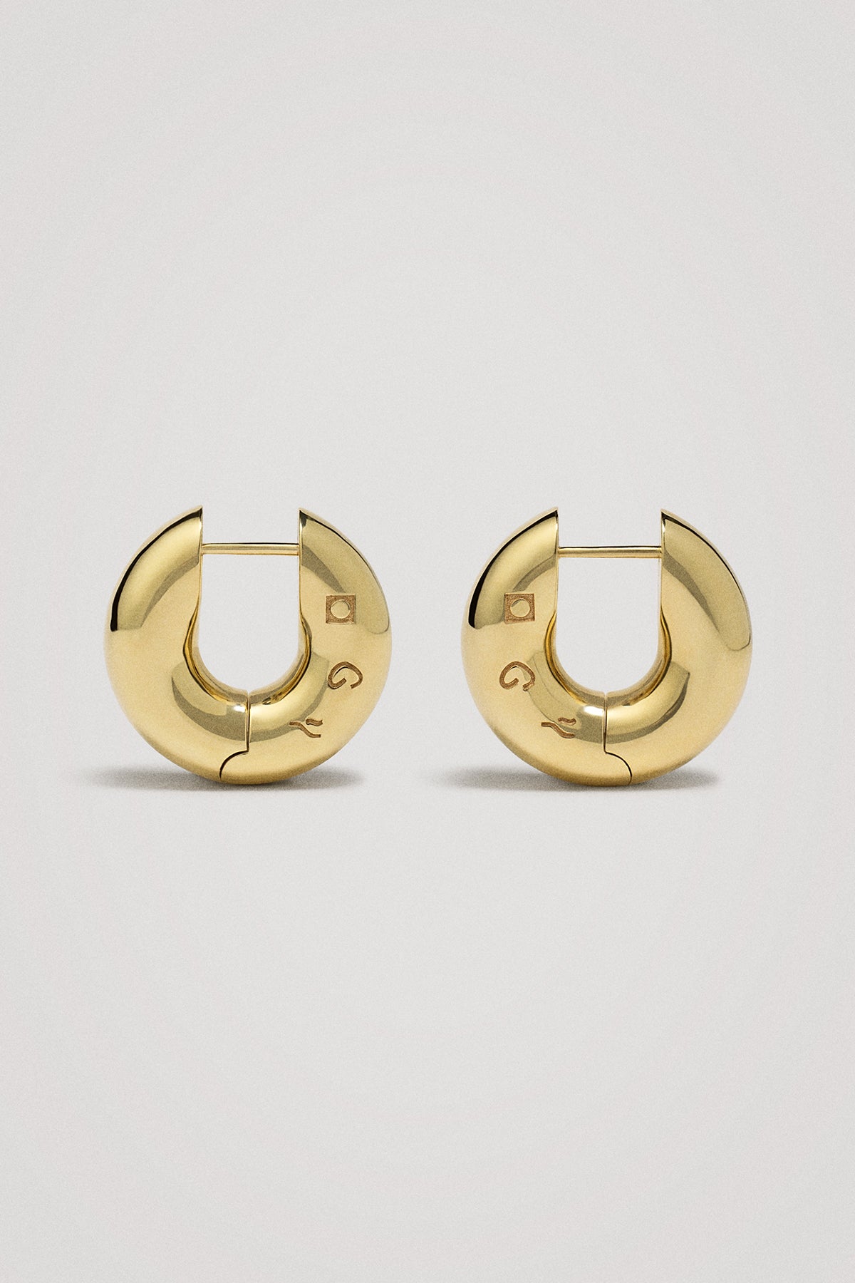 Gold hoop earrings on a light gray background