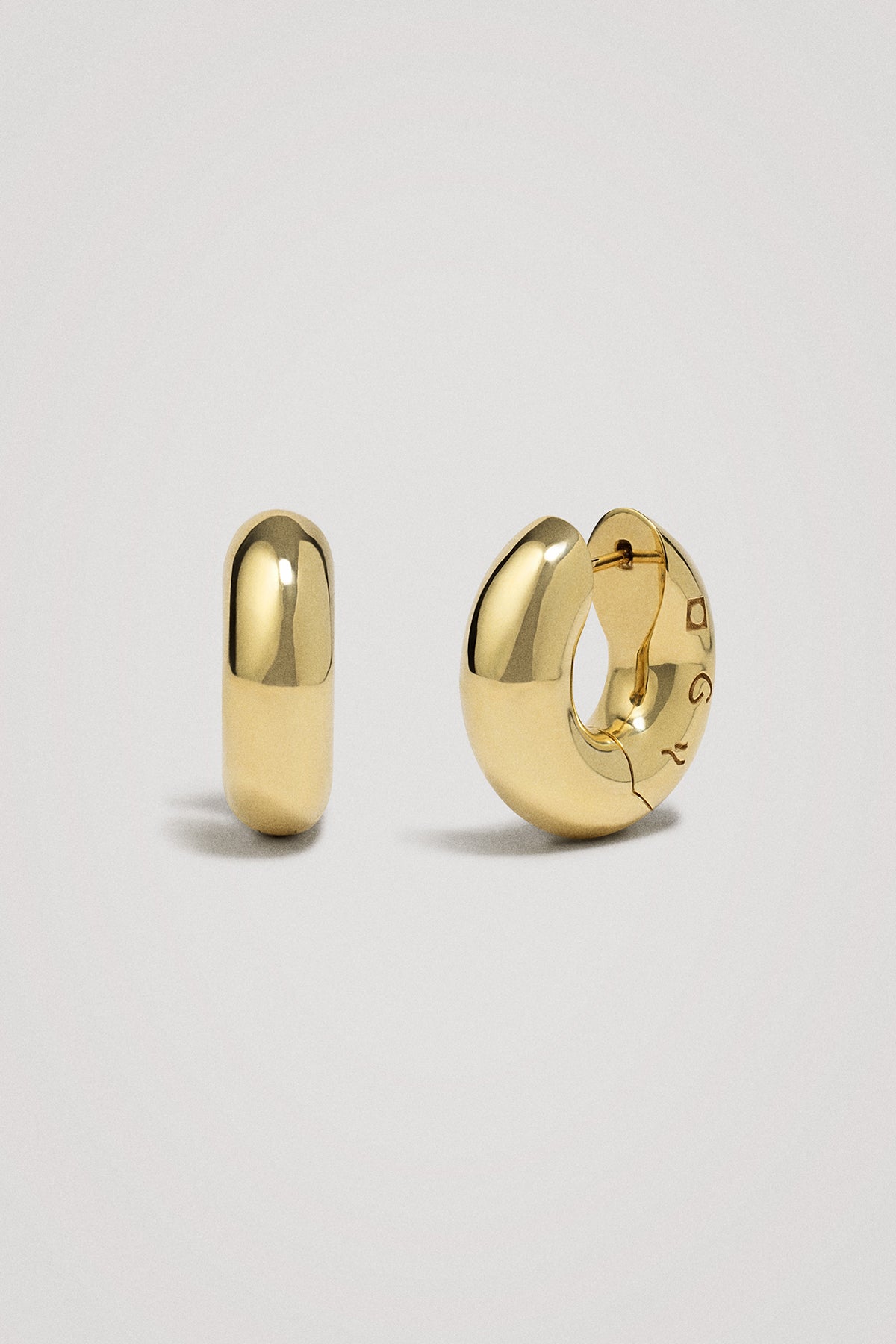 Gold hoop earrings on a light gray background