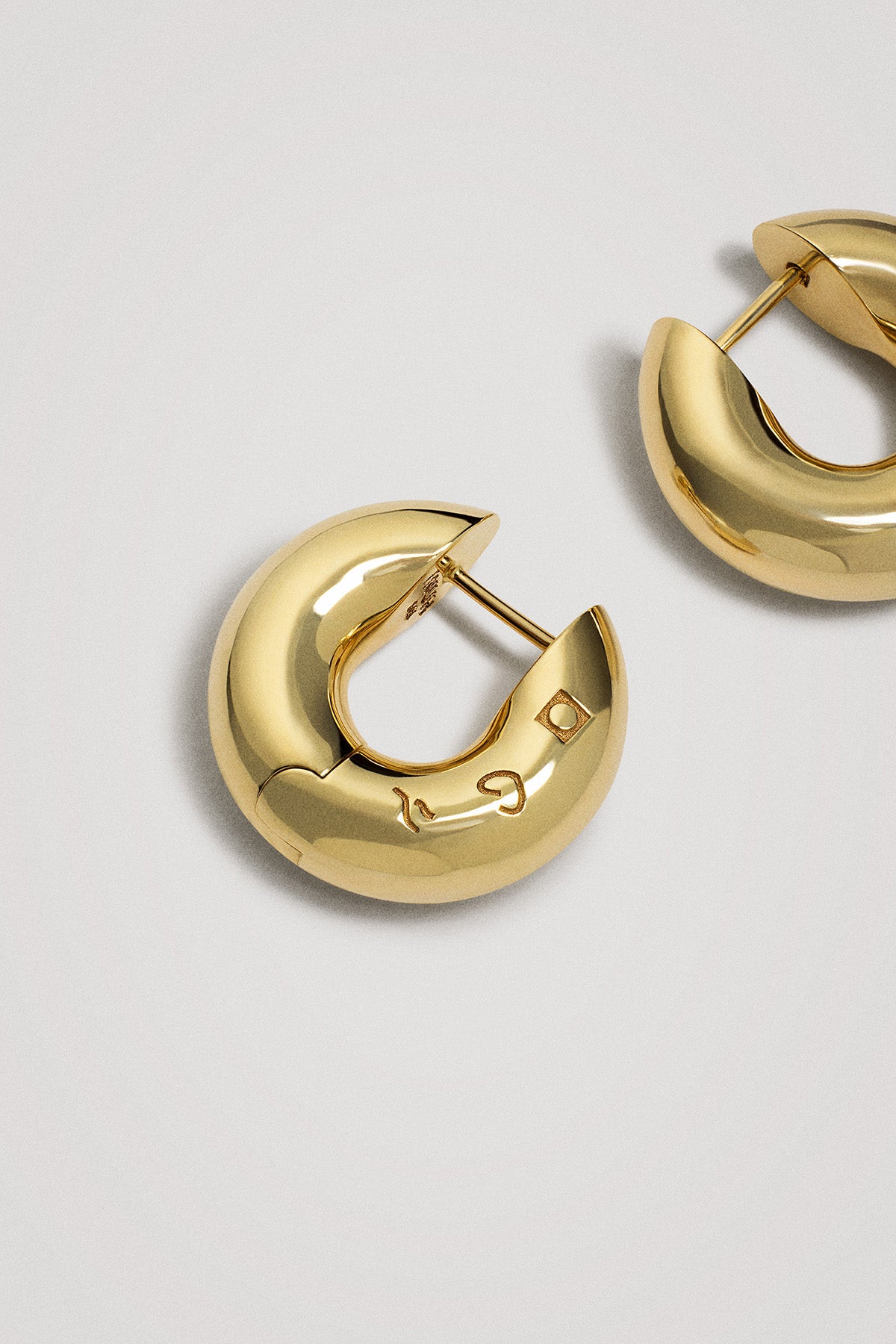 Gold hoop earrings on a light gray background