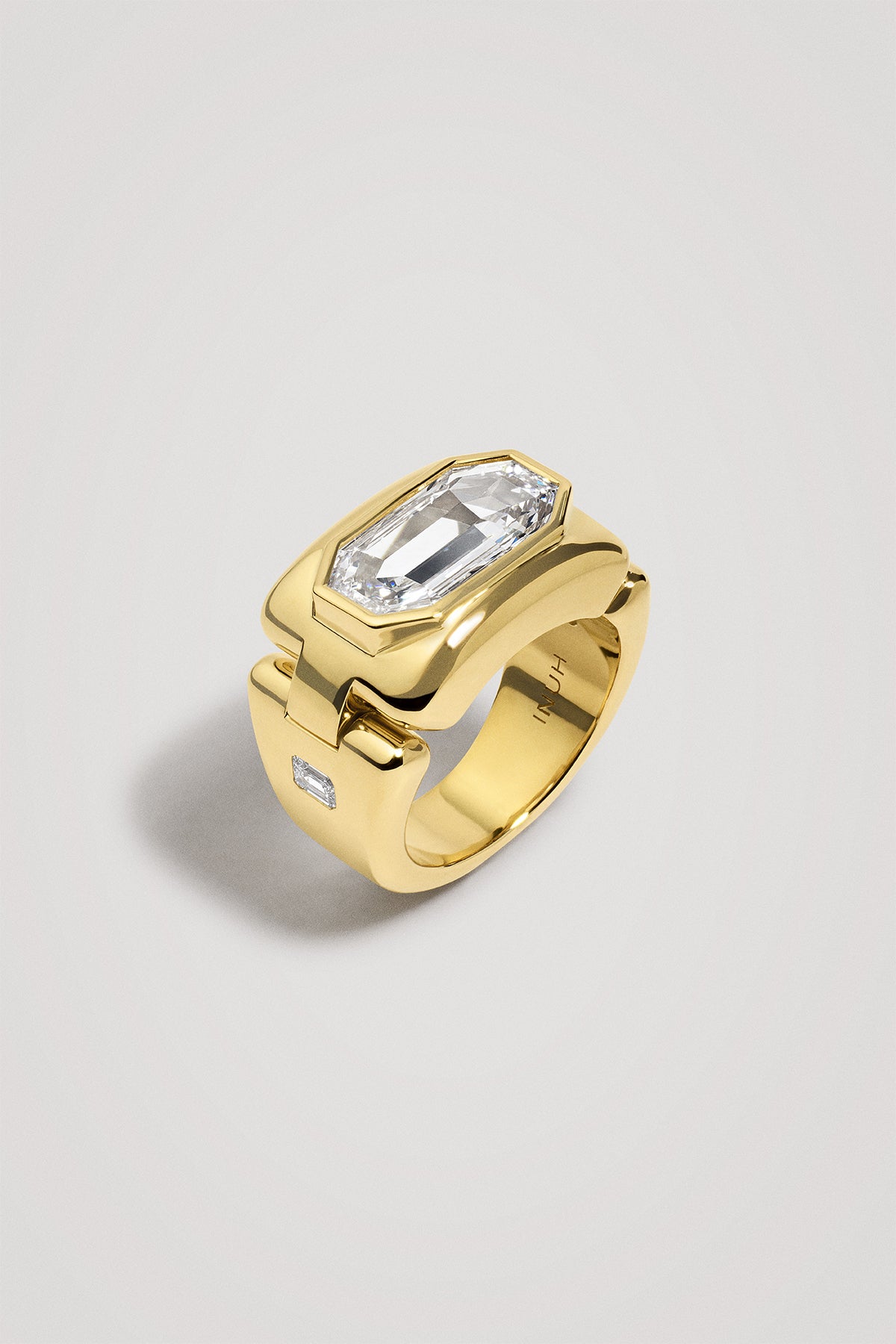 Gold ring with a large diamond on a light gray background