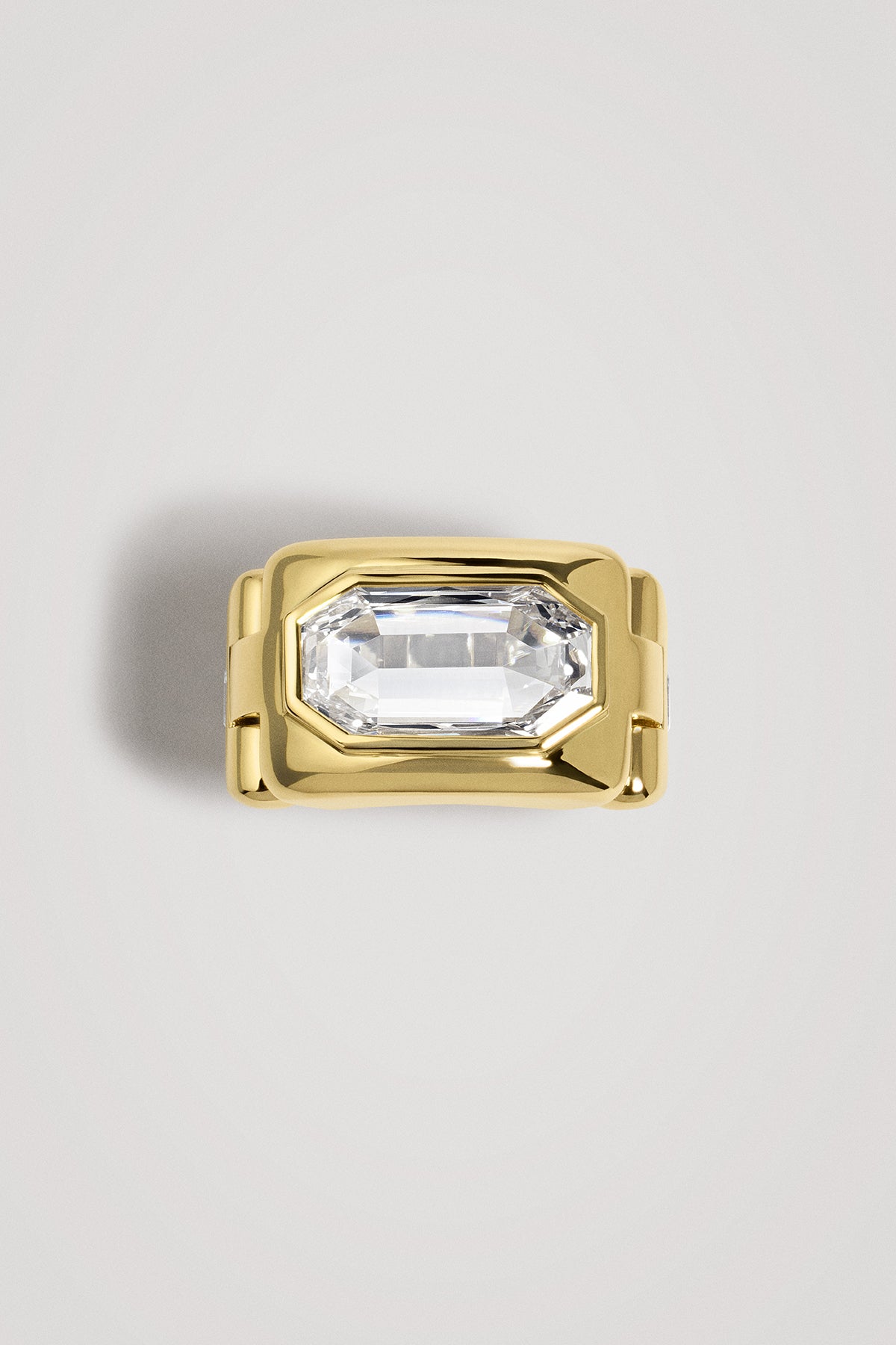 Gold ring with a portrait diamond on a light gray background