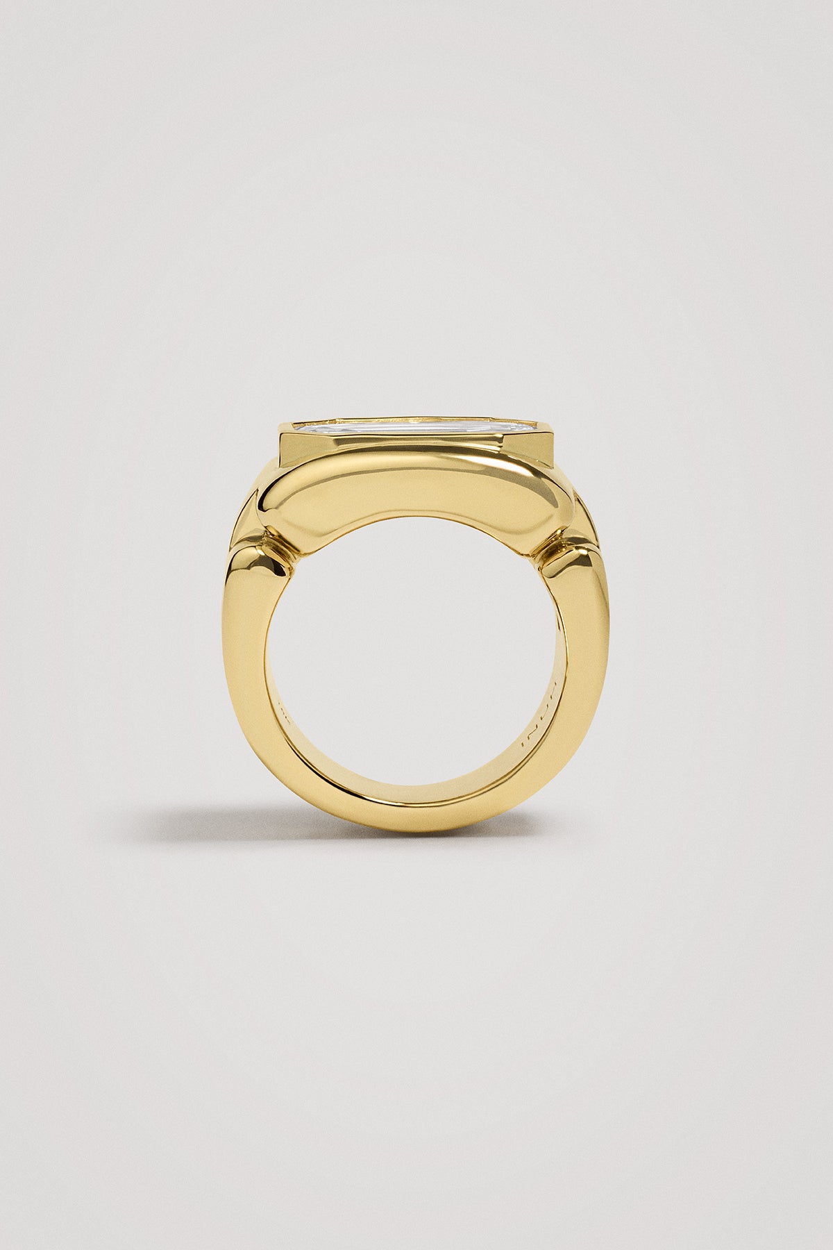 Gold ring with a large diamond on a light gray background