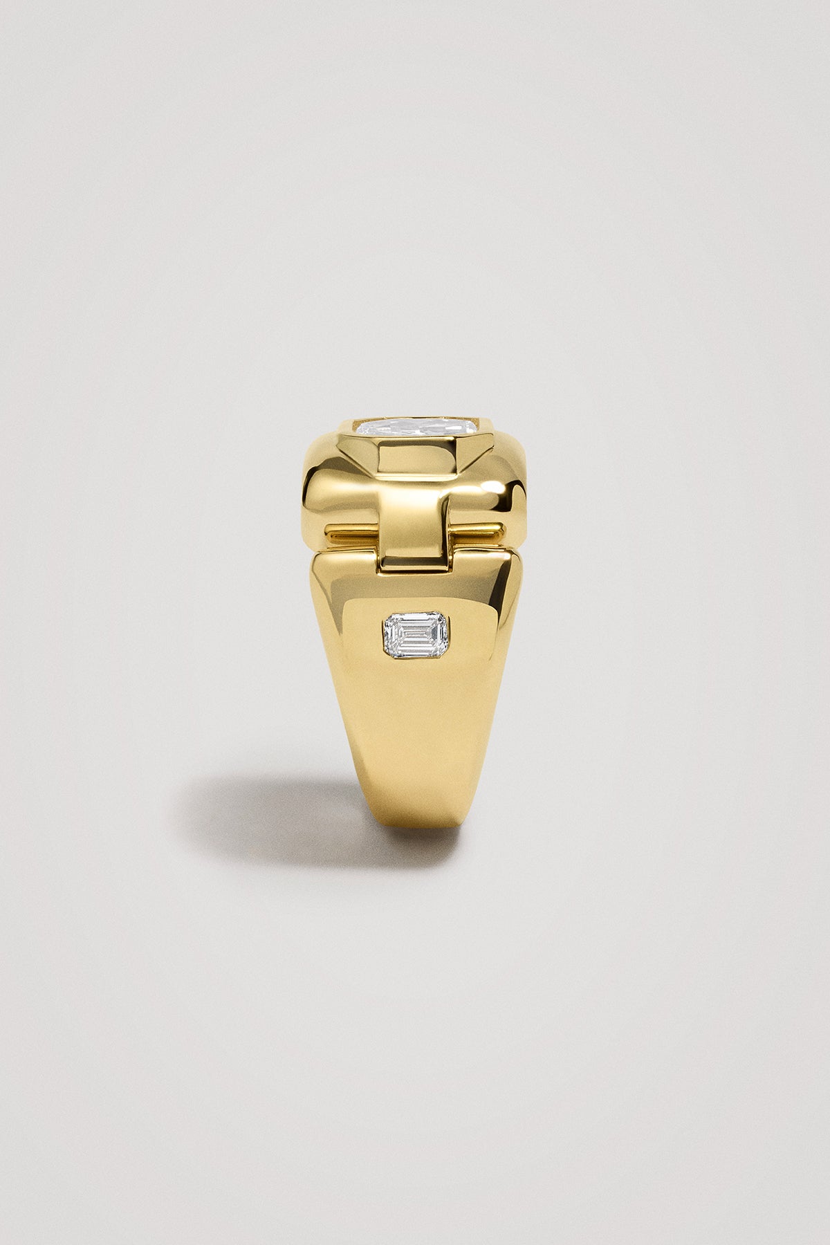 Gold ring with diamonds on a light gray background
