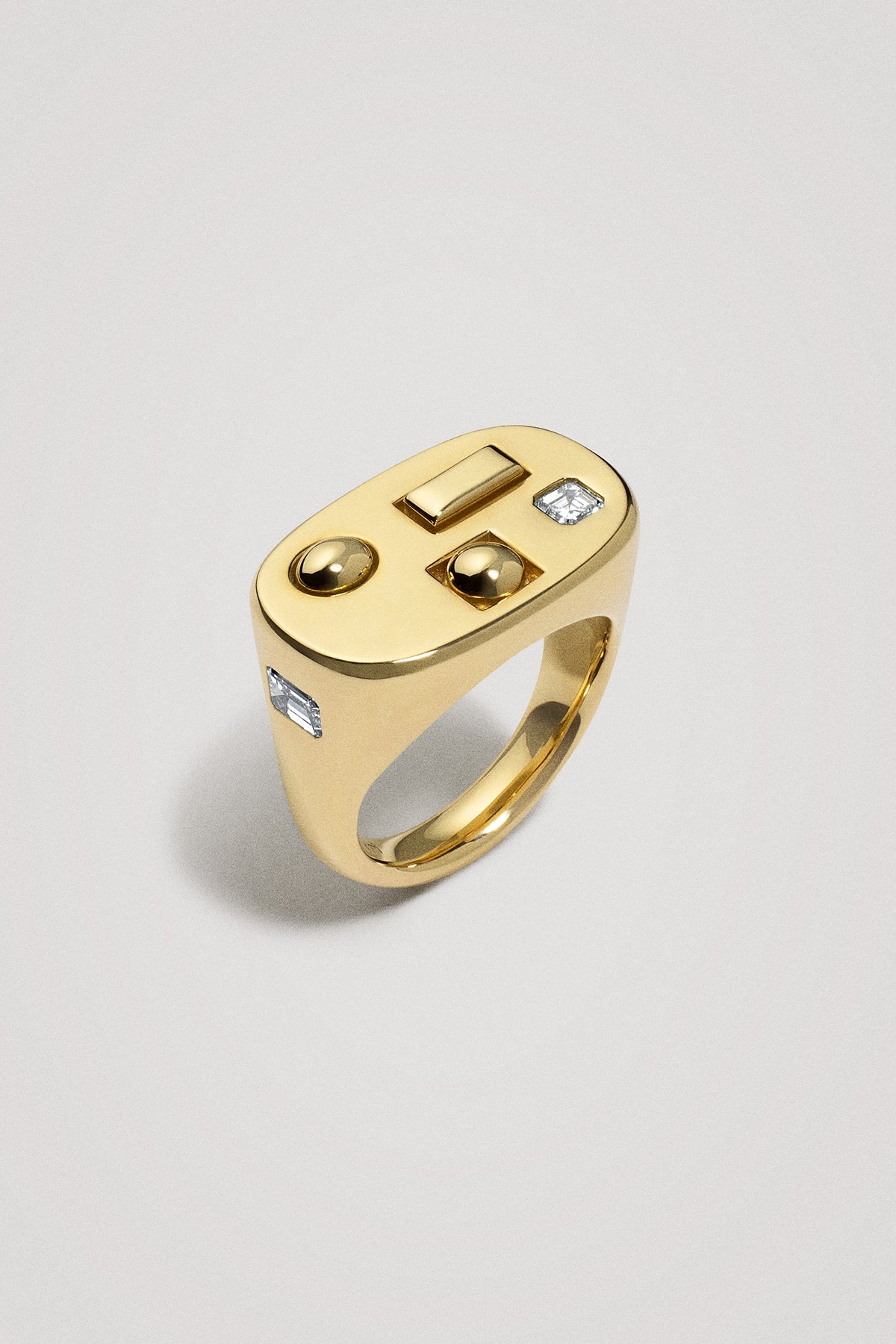 Chunky gold ring with diamonds on a light gray background