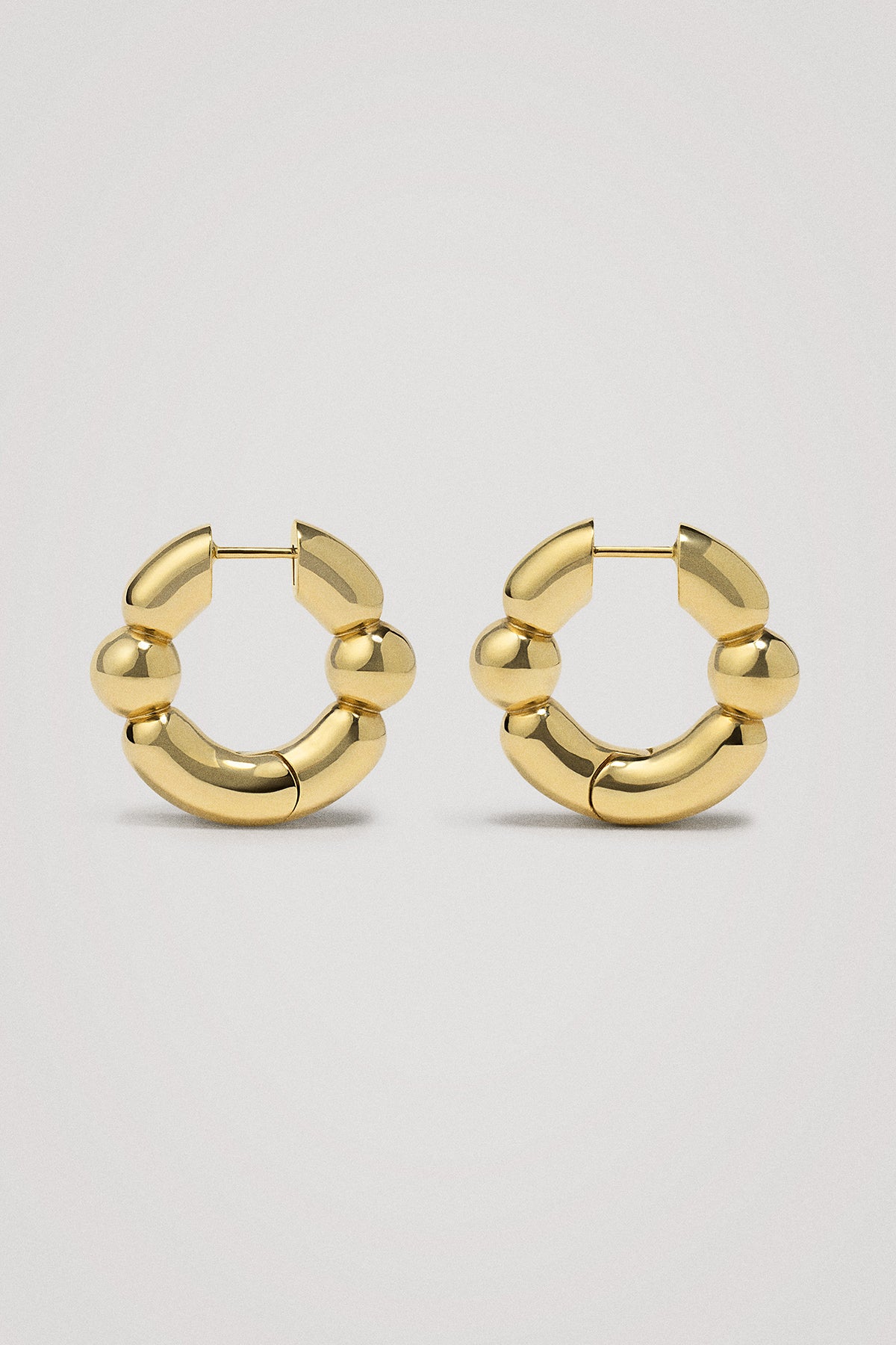Gold hoop earrings on a light gray background