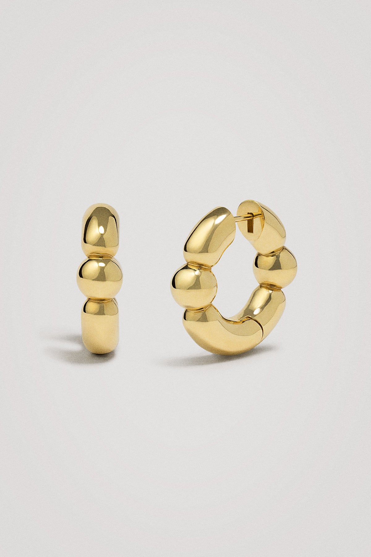 Gold hoop earrings on a light gray background