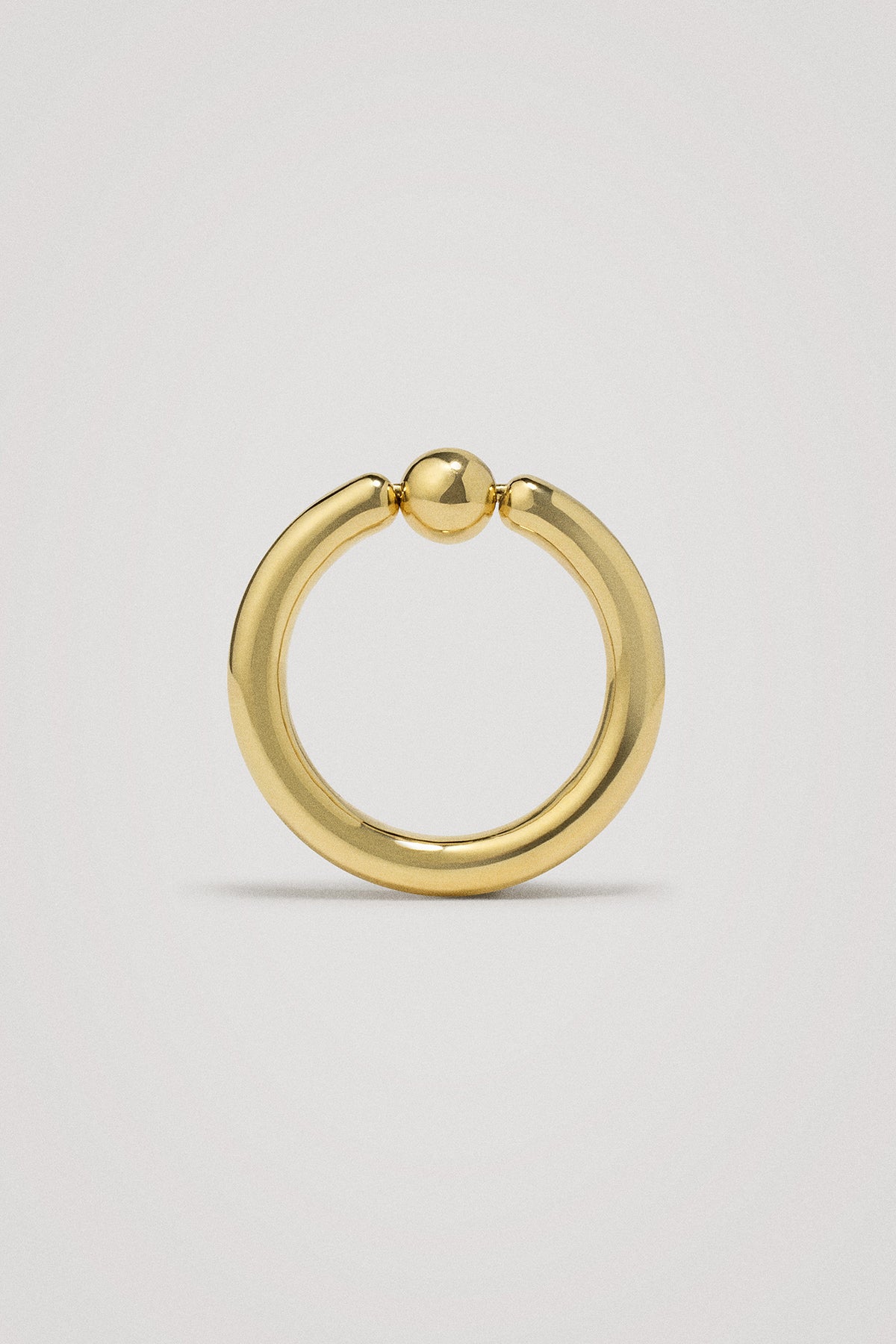 Gold ring on a light gray background